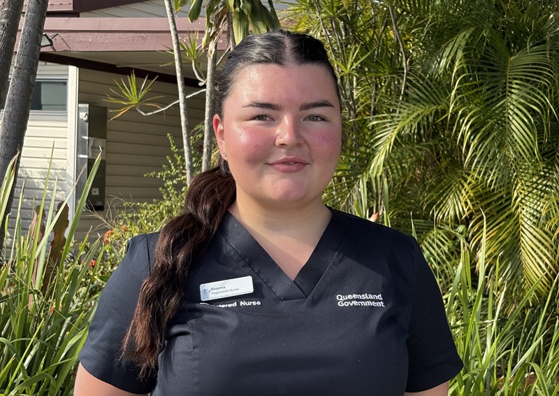 A nurse in blue scrubs stands outside the Dysart Hospital