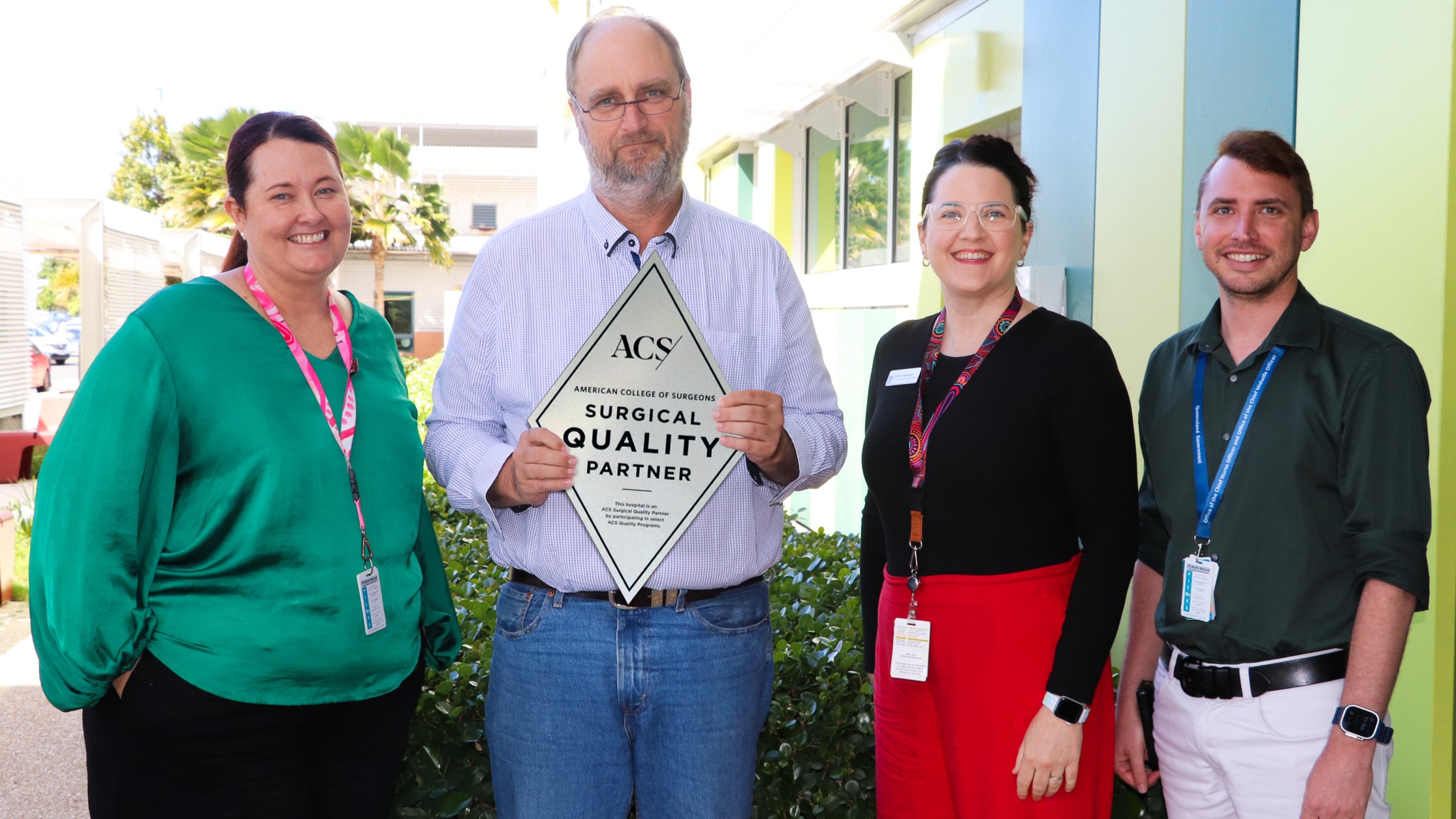 Four hospital staff holding NSQIP plaque