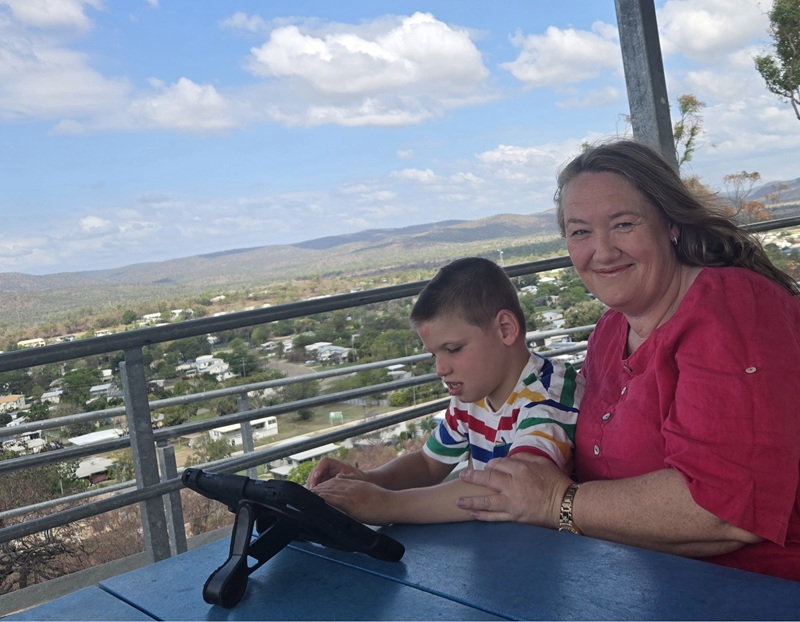 A child sits with his mother and an iPad at a lookout at Collinsville