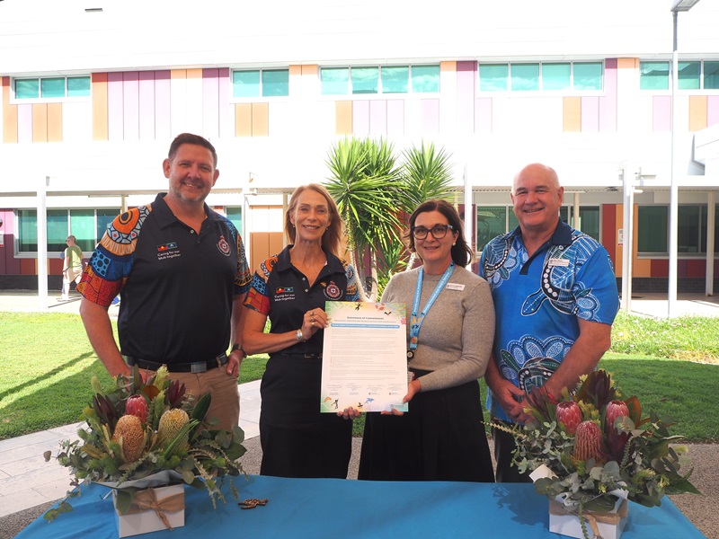 Two QAS and two Mackay HHS leaders pose with the signed Statement of Commitment