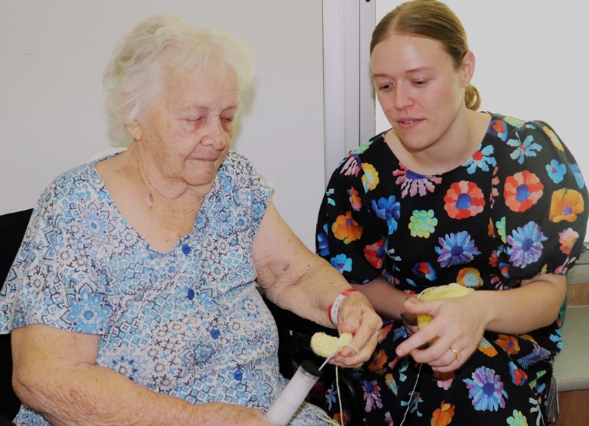An older woman and OT crochet with a ball of wool