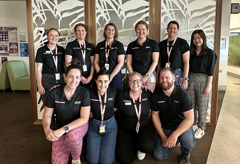 A group of Eat Walk Engage facilitators stand together as a team