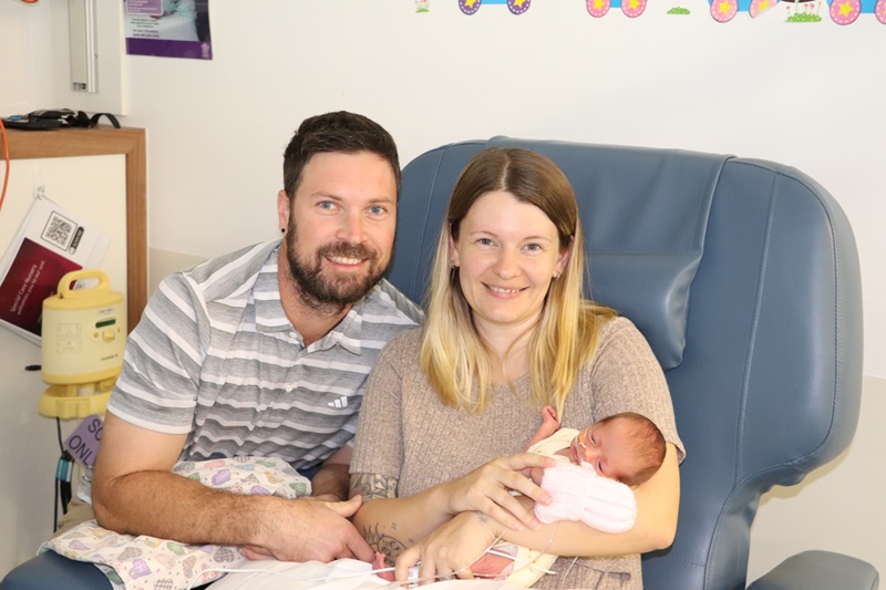 A couple nurse their tiny newborn daughter in the SCN