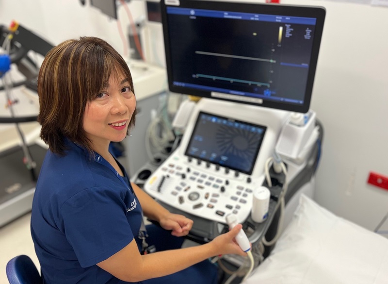A clinical measurements scientist sits at an ECG machine