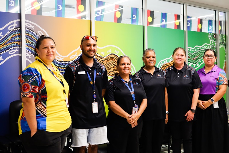 A group of Aboriginal and Torres Strait Islander health liaison officers stand out the front of their new office space.