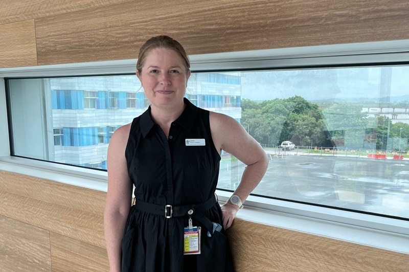 A dietician stands in a hospital hallway