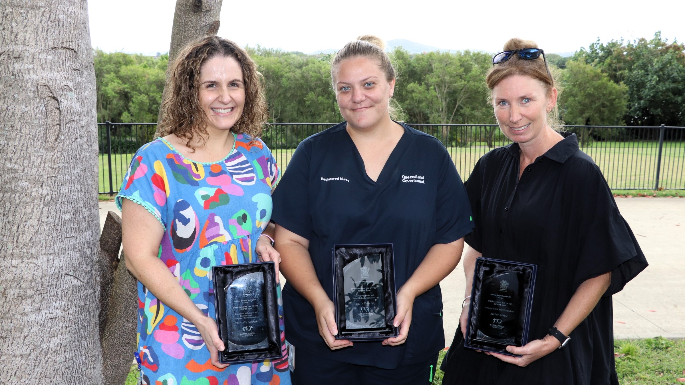 Three midwives hold award trophies