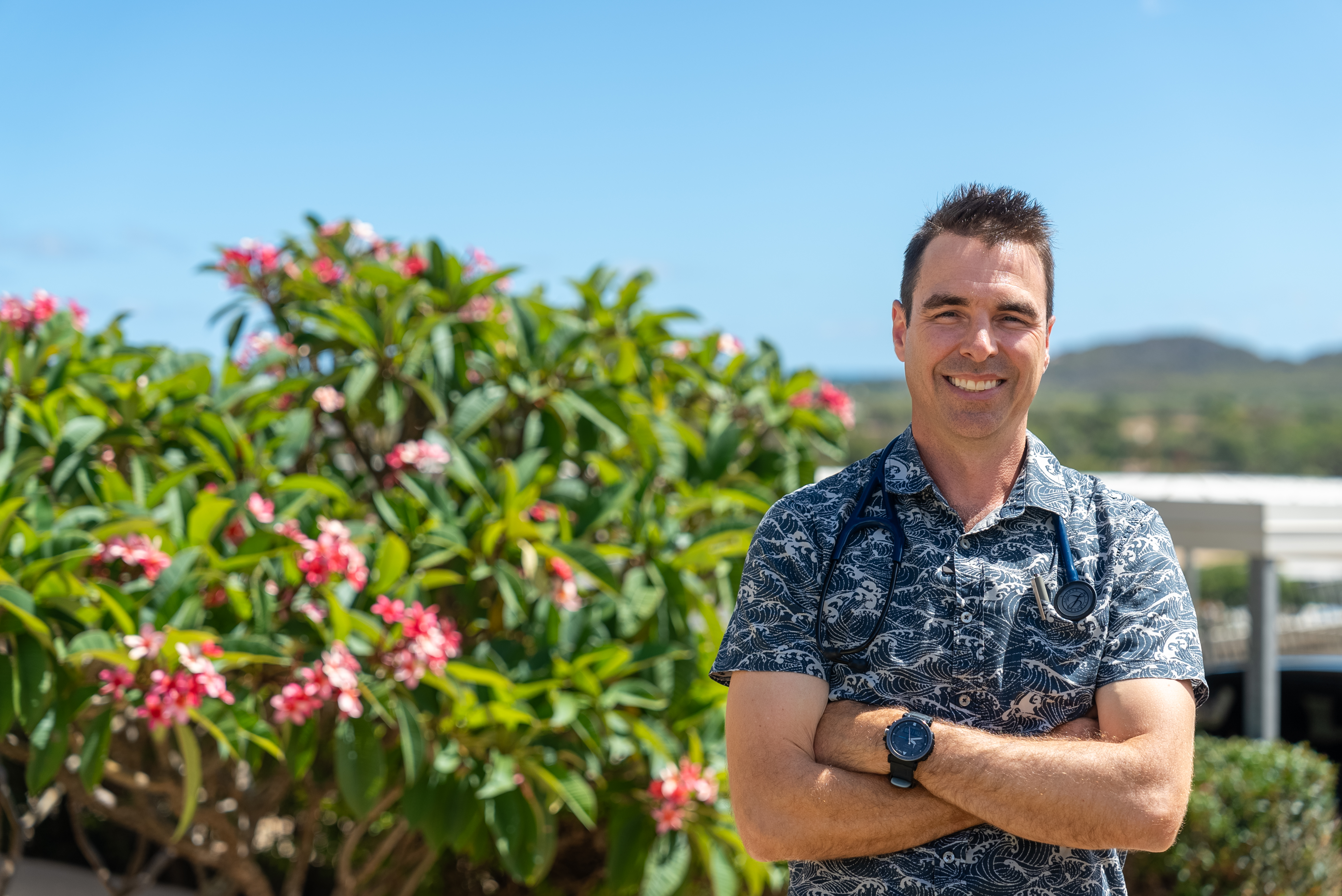 Bowen Hospital doctor standing on hospital grounds in front of a tree